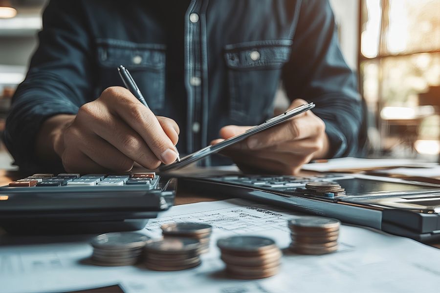 Foto: Person mit Stift und Taschenrechner